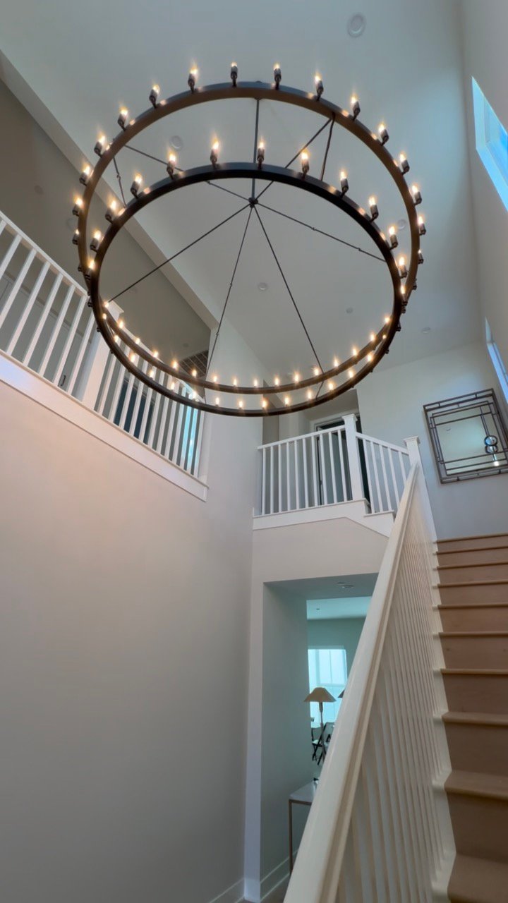United chandelier installation above a staircase
